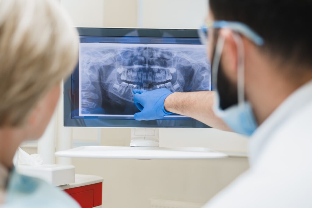 Dentist examining a patient’s painful tooth before root canal treatment in Medford OR