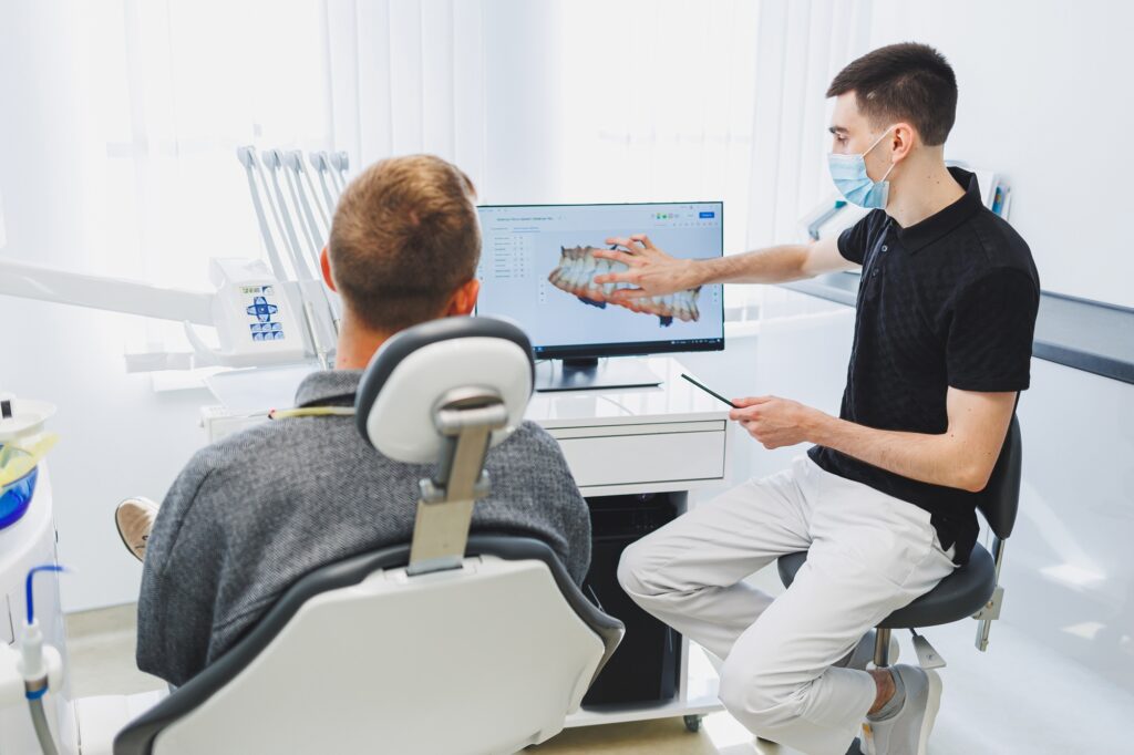 Dentist showing a patient a digital CEREC crown design on a screen in Medford OR